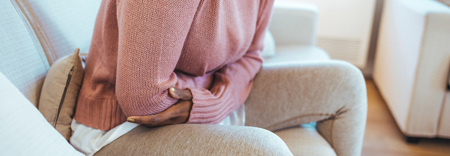 nainen pitelee vatsaansa